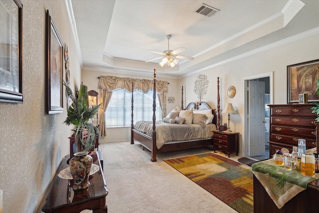 bedroom featuring ceiling fan, light carpet, crown molding, and a tray ceiling