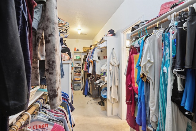 spacious closet featuring light colored carpet