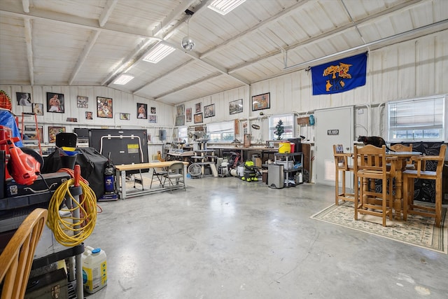 garage featuring wooden walls and a workshop area