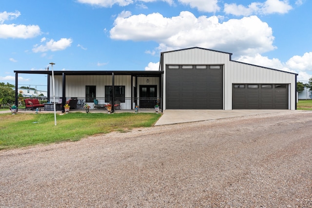 garage with a yard and covered porch