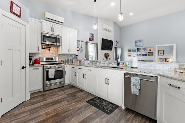 kitchen featuring white cabinets, a wall mounted AC, stainless steel appliances, dark hardwood / wood-style floors, and a towering ceiling