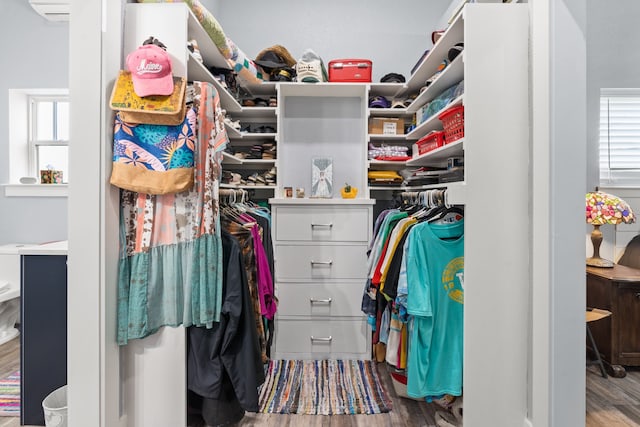 spacious closet with a wall unit AC and hardwood / wood-style flooring