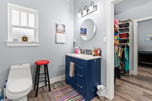 bathroom featuring wood-type flooring, vanity, and toilet