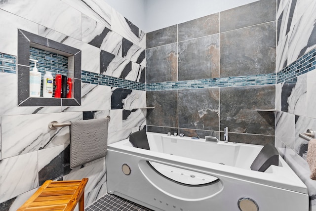 bathroom with tile walls, tile patterned flooring, and a tub