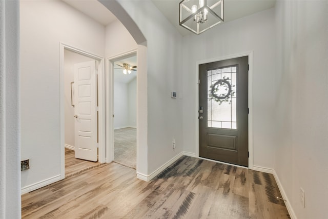 entryway featuring ceiling fan with notable chandelier and hardwood / wood-style flooring