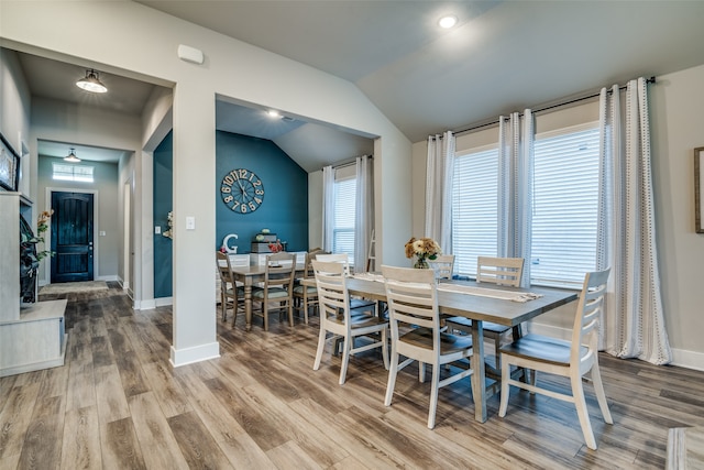 dining area featuring hardwood / wood-style flooring, lofted ceiling, and a healthy amount of sunlight