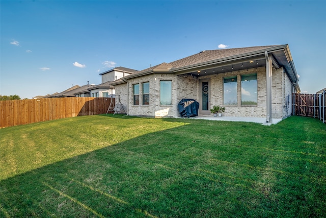 rear view of house with a lawn and a patio