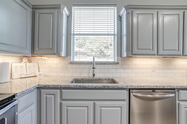 kitchen with backsplash, stainless steel dishwasher, sink, and gray cabinets