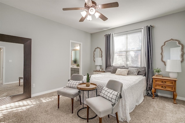 bedroom featuring ceiling fan, light colored carpet, and connected bathroom