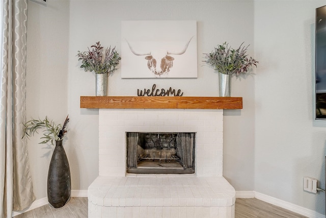 interior details with hardwood / wood-style floors and a brick fireplace