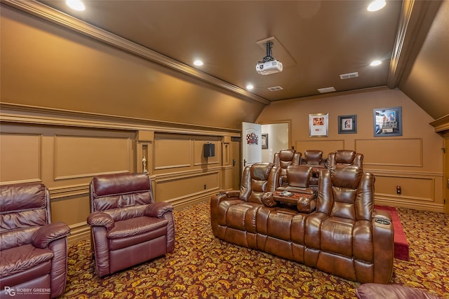 carpeted cinema room with ornamental molding and lofted ceiling