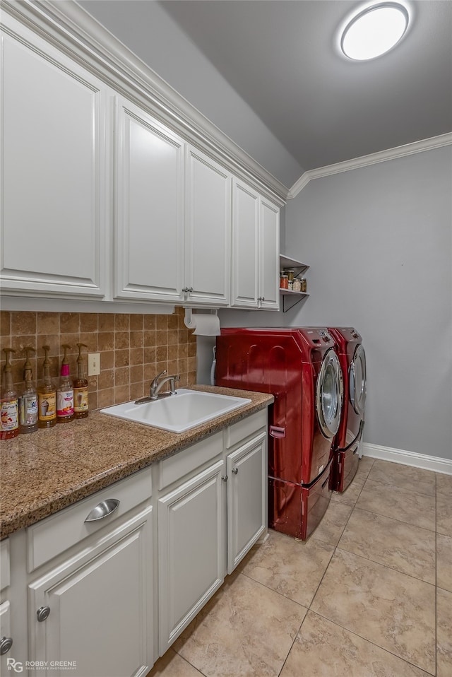 washroom featuring cabinets, washer and clothes dryer, crown molding, and sink