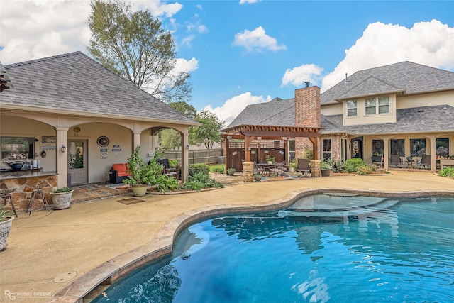 view of swimming pool featuring exterior bar and a patio