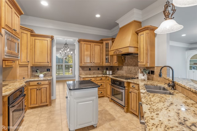 kitchen with sink, hanging light fixtures, a notable chandelier, light stone counters, and stainless steel appliances