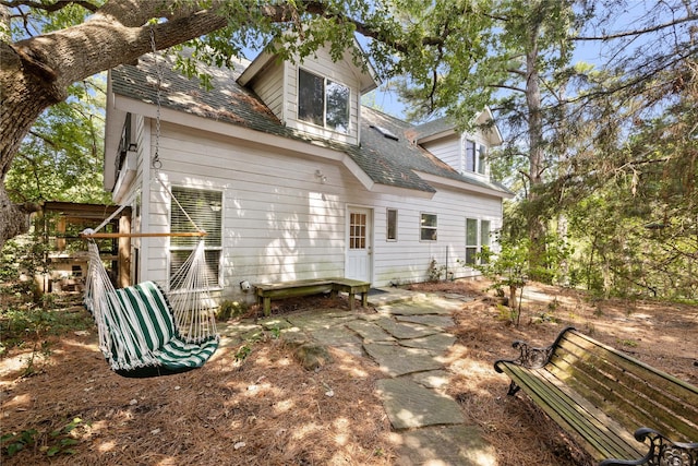 back of property featuring roof with shingles