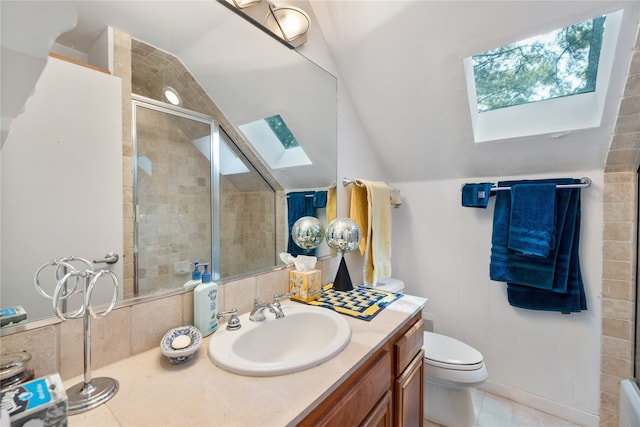 bathroom featuring vaulted ceiling with skylight, walk in shower, toilet, tile patterned floors, and vanity