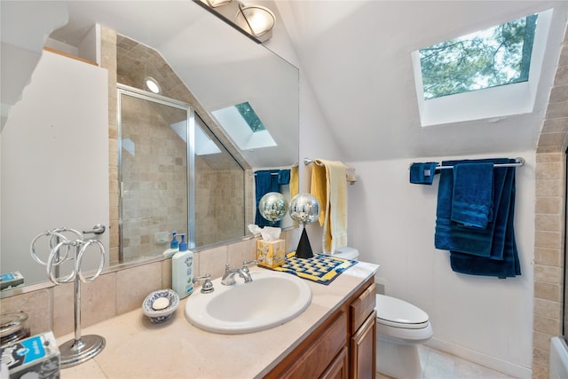 full bath featuring tile patterned floors, lofted ceiling with skylight, vanity, a tile shower, and toilet