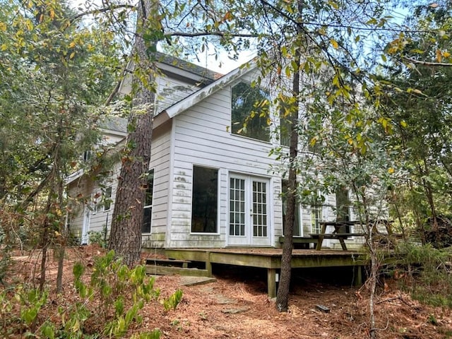 view of side of home with a wooden deck and french doors