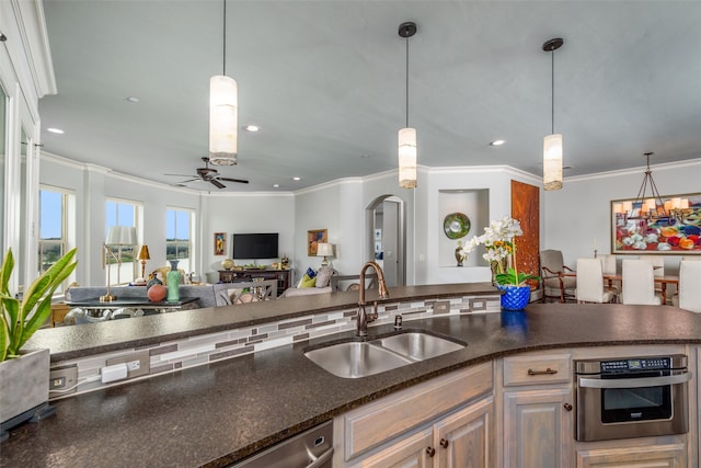 kitchen featuring ceiling fan with notable chandelier, crown molding, sink, and decorative light fixtures