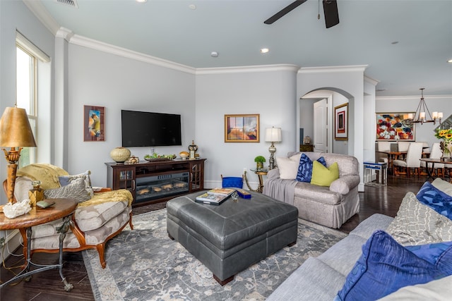 living room featuring ceiling fan with notable chandelier, crown molding, a fireplace, and dark hardwood / wood-style flooring