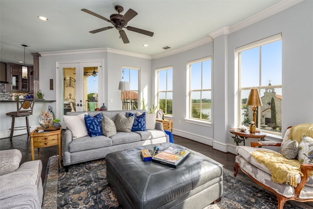 living room with a healthy amount of sunlight, crown molding, dark wood-type flooring, and ceiling fan