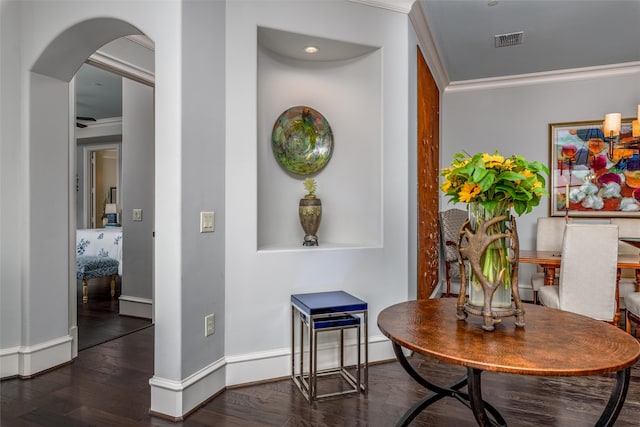 interior space with ornamental molding and dark hardwood / wood-style flooring