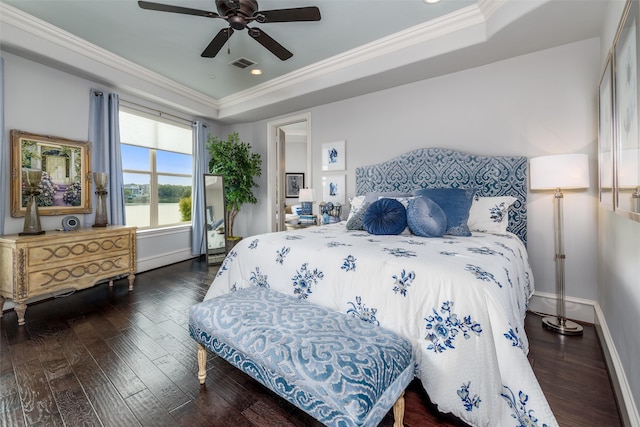 bedroom with ceiling fan, ornamental molding, a tray ceiling, and dark hardwood / wood-style flooring