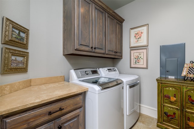 clothes washing area featuring washing machine and dryer, light tile patterned floors, and cabinets