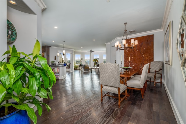 dining area with ceiling fan with notable chandelier, ornamental molding, and dark wood-type flooring