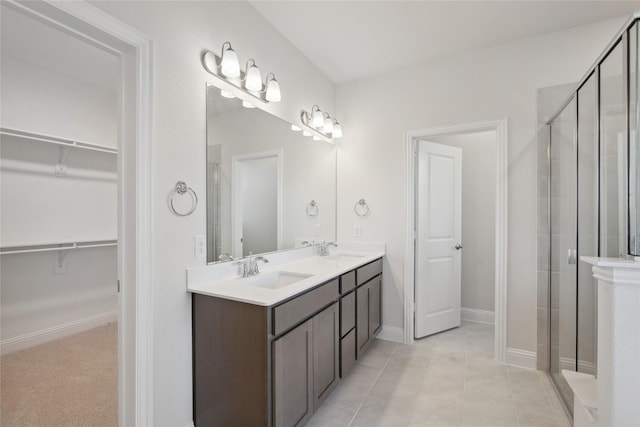 bathroom featuring vanity, a shower with shower door, and tile patterned flooring