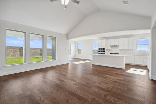 unfurnished living room with ceiling fan, dark hardwood / wood-style flooring, and high vaulted ceiling