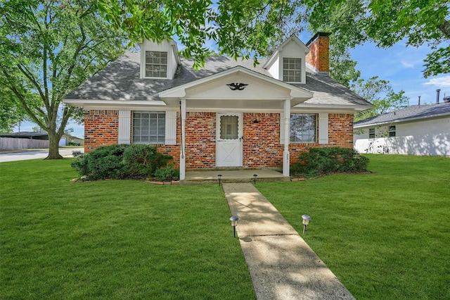 new england style home with covered porch and a front yard