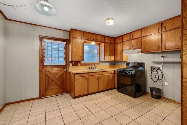 kitchen featuring sink, a textured ceiling, ornamental molding, black gas range oven, and light tile patterned floors