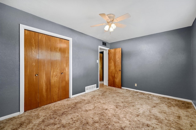 unfurnished bedroom featuring a closet, carpet floors, and ceiling fan