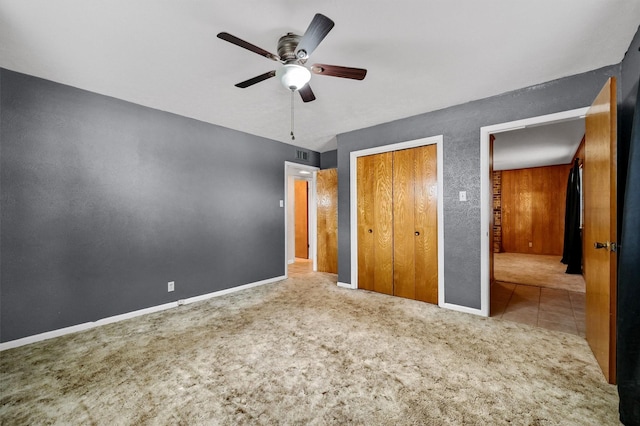 unfurnished bedroom featuring ceiling fan, light colored carpet, and a closet