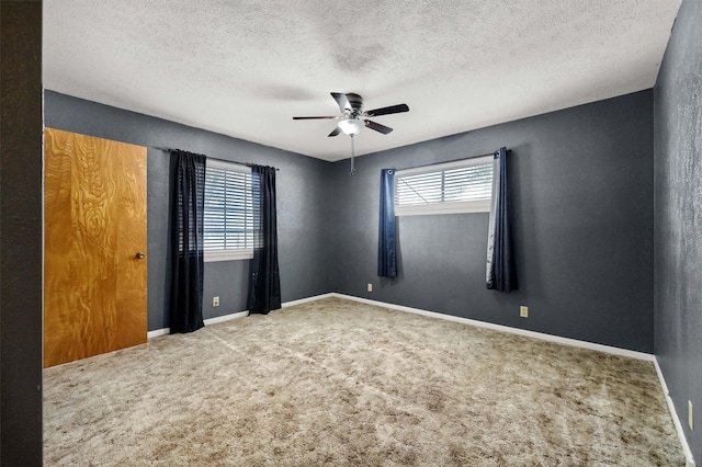 spare room with a textured ceiling, ceiling fan, and carpet floors