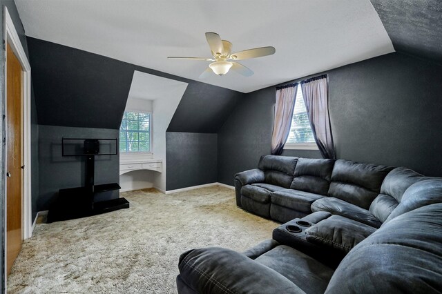 carpeted living room with ceiling fan and lofted ceiling