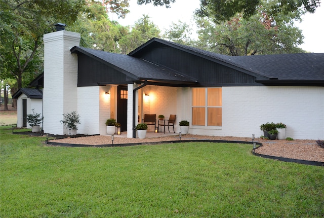 rear view of property with a patio and a yard