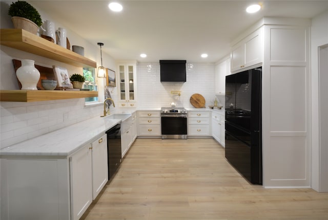 kitchen featuring light stone countertops, white cabinets, black appliances, and decorative light fixtures