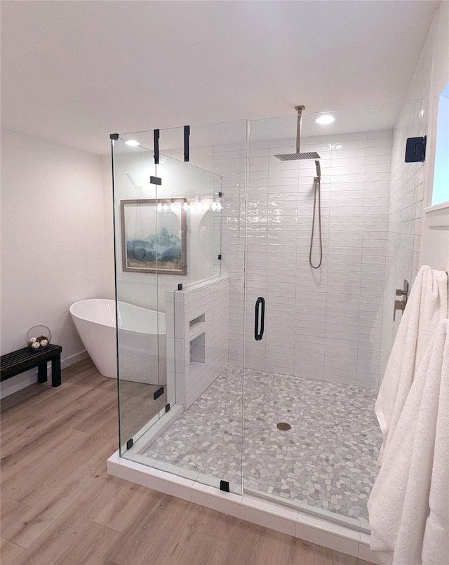 bathroom featuring hardwood / wood-style flooring and plus walk in shower