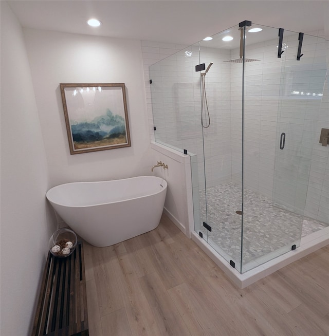 bathroom featuring shower with separate bathtub and hardwood / wood-style flooring