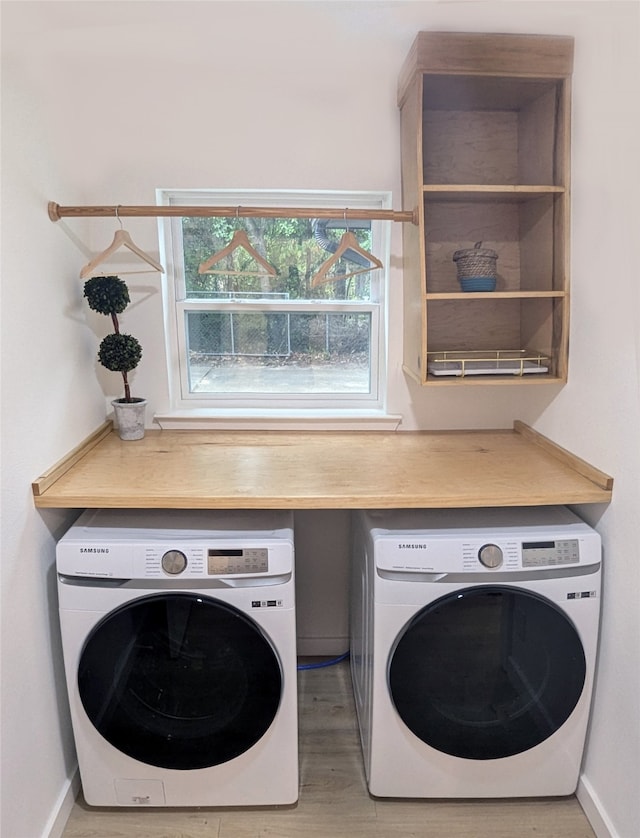 washroom featuring wood-type flooring and separate washer and dryer