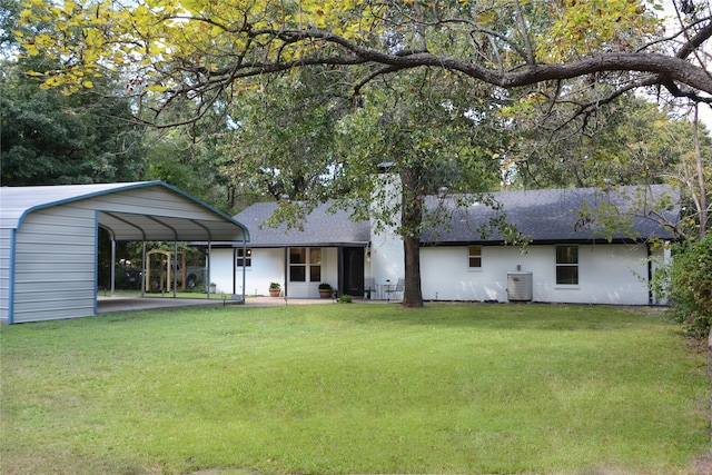 rear view of property with a lawn and a carport