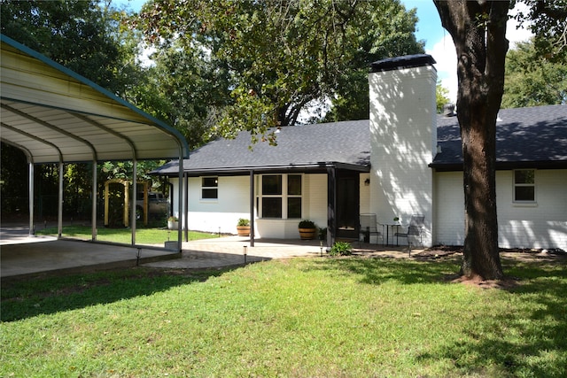 rear view of house with a patio and a lawn