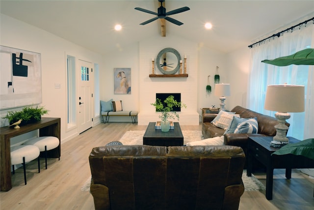 living room with light hardwood / wood-style flooring, vaulted ceiling, and ceiling fan