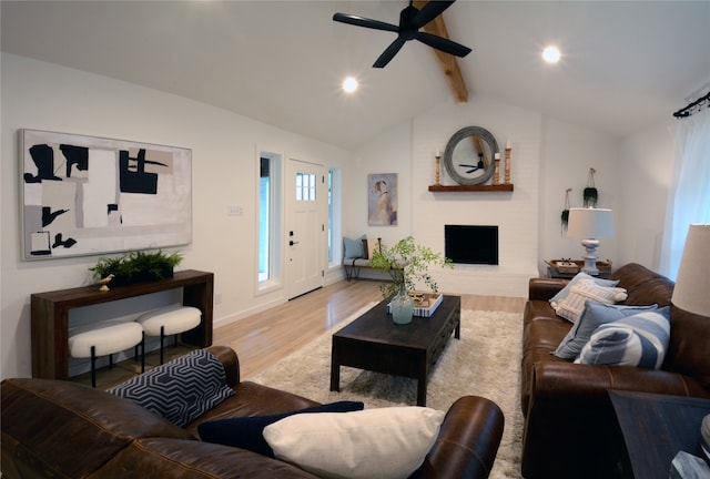 living room featuring lofted ceiling with beams, light wood-type flooring, and ceiling fan