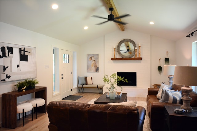 living room with vaulted ceiling with beams, ceiling fan, and light hardwood / wood-style flooring