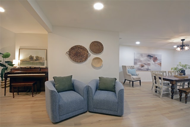 living room featuring light wood-type flooring and an inviting chandelier