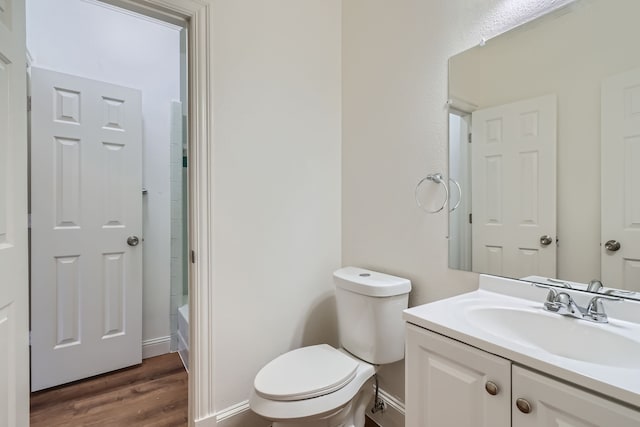 full bathroom featuring tub / shower combination, hardwood / wood-style flooring, vanity, and toilet