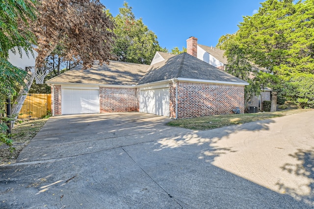 view of front of home featuring cooling unit and a garage